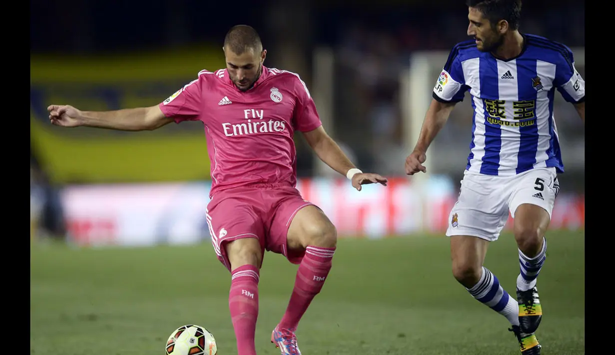 Penyerang Real Madrid, Karim Benzema (kiri), mencoba mengecoh gelandang bertahan Real Sociedad, Markel Bergara, saat berlaga di lanjutan La Liga 2014-2015 di Stadion Anoeta, (1/9/2014). (REUTERS/Vincent West) 