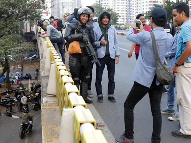 Mahasiswa dari salah satu perguruan tinggi berfoto dengan personel Brimob usai melakukan aksi unjuk rasa di sekitar Jembatan Layang Gerbang Pemuda, Jakarta, Selasa (1/10/2019). Mahasiswa dari berbagai perguruan tinggi kembali berunjuk rasa menolak beberapa RUU. (Liputan6.com/Helmi Fithriansyah)