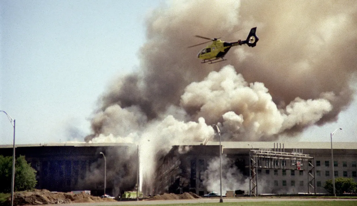 File foto sebuah helikopter terbang di atas Pentagon di Washington saat asap mengepul di atas gedung pada 11 September 2001, setelah sebuah pesawat yang dibajak menabrak sisi barat gedung, menewaskan 184 orang. (AP Photo/Heesoon Yim, File)