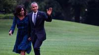 Presiden Amerika Serikat (AS) ke-44, Barack Obama menggandeng tangan sang istri, Michelle Obama, sambil menyapa awak media saat berjalan di halaman sisi selatan Gedung Putih di Washington, 28 September 2016. (AFP PHOTO / ZACH GIBSON)