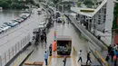 Warga berjalan di atas papan kayu melintasi banjir di stasiun metro Zeytinburnu, Selasa (18/7). Jalanan Istanbul berubah menjadi sungai akibat curah hujan yang biasanya mengguyur Turki selama satu tahun penuh, terjadi hanya dalam 12 jam. (YASIN AKGUL/AFP)