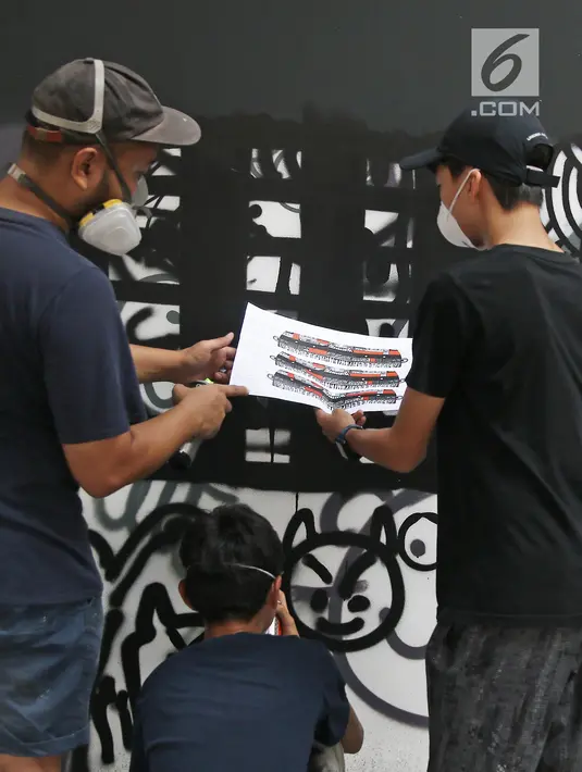 Siswa Menengah dan Menengah Atas Jakarta Intercultural School (JIS) dan Darbotz, seniman Mural Art kenamaan Indonesia (kedua kiri), tengah berdiskusi di workshop melukis mural di dinding sekolah, Jakarta, Sabtu (7/4). (Liputan6.com/Herman Zakharia)