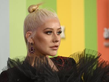 Penyanyi Christina Aguilera berpose saat tiba menghadiri 10th amfAR Gala di Los Angeles, California (11/10/2019). Aguilera tampil anggun dengan gaun hitam serta celana merah berkilau. (AFP Photo/Nick Agro)