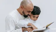 Ilustrasi Islami, muslim, mengaji, membaca Al-Qur'an. (Foto oleh Timur Weber: https://www.pexels.com/id-id/foto/duduk-anak-orang-tua-membaca-9127593/)