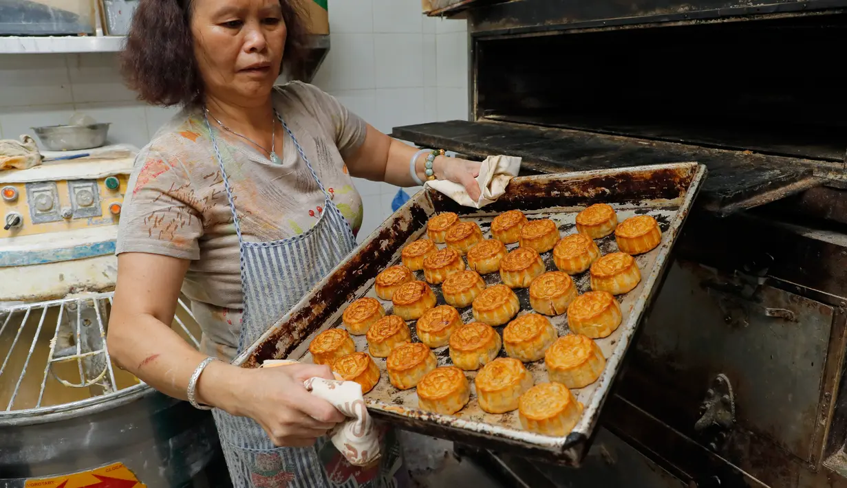 Pekerja memegang nampan kue bulan dengan kata-kata China 'orang Hong Kong' di toko roti Wah Yee Tang, Hong Kong, 9 Agustus 2019. Biasanya, kue bulan dipesan dan dinikmati saat Festival Pertengahan Musim Gugur. (AP Photo/Kin Cheung)