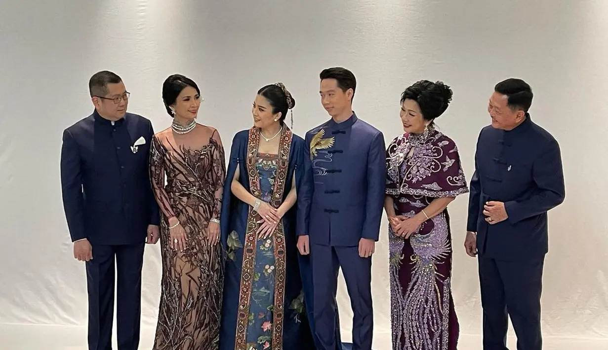 Saat acara Teapai, Nia tampil elegan dibalut cape cheongsam dress nuansa warna ungu tua.