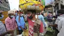 Pekerja upahan harian dan penjual buah mengenakan masker di pasar grosir di Bengaluru, India, Kamis (24/9/2020). Negara berpenduduk 1,3 miliar itu diperkirakan akan menjadi negara terparah pandemi COVID-19 dalam beberapa minggu, melampaui AS. (AP Photo/Aijaz Rahi)