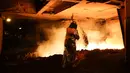Seorang pekerja mengenakan pakaian pelindung membuat baja di Salzgitter, Jerman (22/3). Di pabrik ini, pasir besi bisa diolah menjadi baja dengan lapisan yang kuat. (AP Photo / Markus Schreiber)