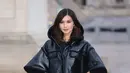 Bintang film Crazy Rich Asian dan Eternals Gemma Chan, tampil memukau saat menghadiri peragaan Busana Louis Vuitton. Akris  38 tahun ini memamerkan selera gayanya dalam balutan mantel hitam yang eye-catching dengan lengan mengembang dan kerah yang dramatis. (Dok/Louis Vuitton).