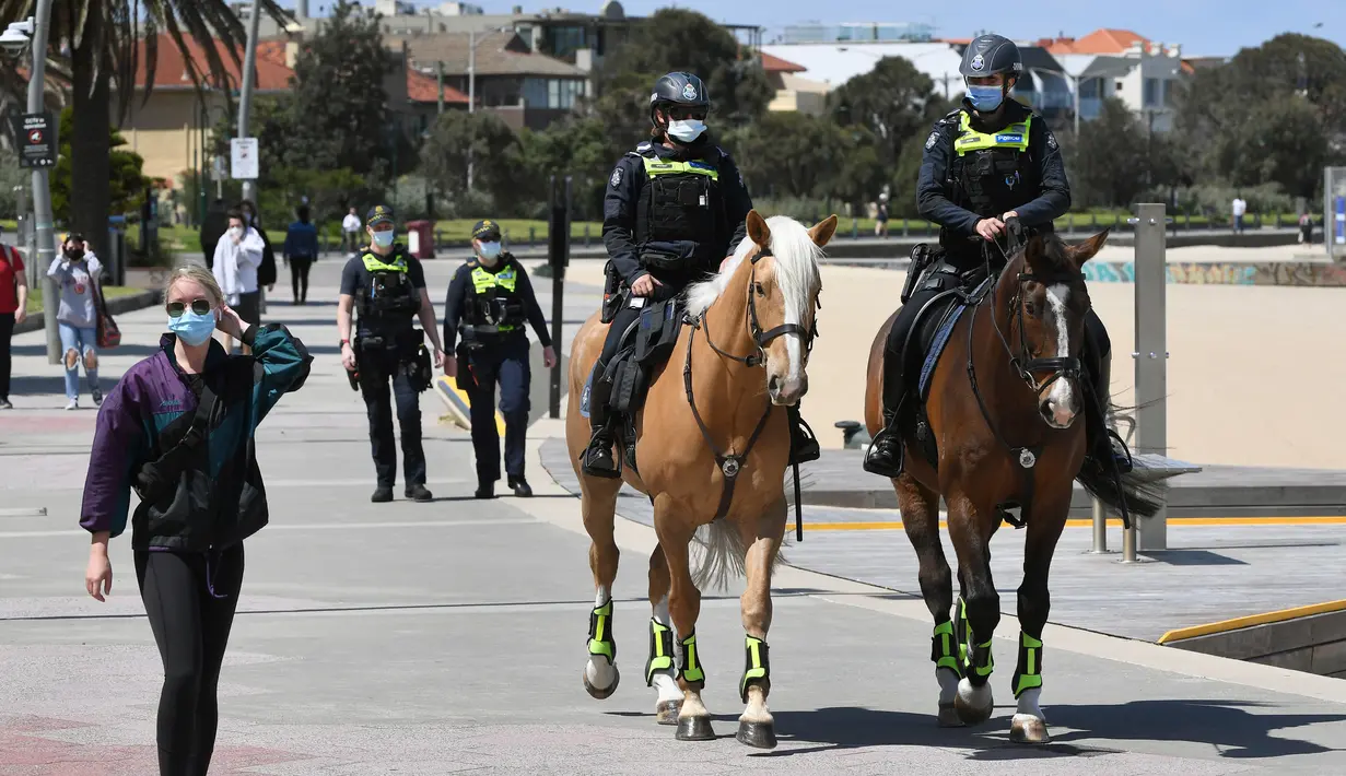 Polisi berpatroli dengan menunggang kuda di sepanjang St Kilda Esplanade di Melbourne (26/10/2020). Pejabat kesehatan Australia melaporkan tidak ada kasus virus corona baru atau kematian di negara bagian Victoria. (AFP Photo/William West)