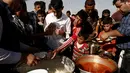 Sejumlah Warga berebut makanan saat mengungsi di kamp Khazer, Irak, (11/11). Warga terpaksa melarikan diri saat Pasukan Irak dan kelompok militan ISIS bentrok memberebutkan kota Mosul. (REUTERS/Zohra Bensemra)