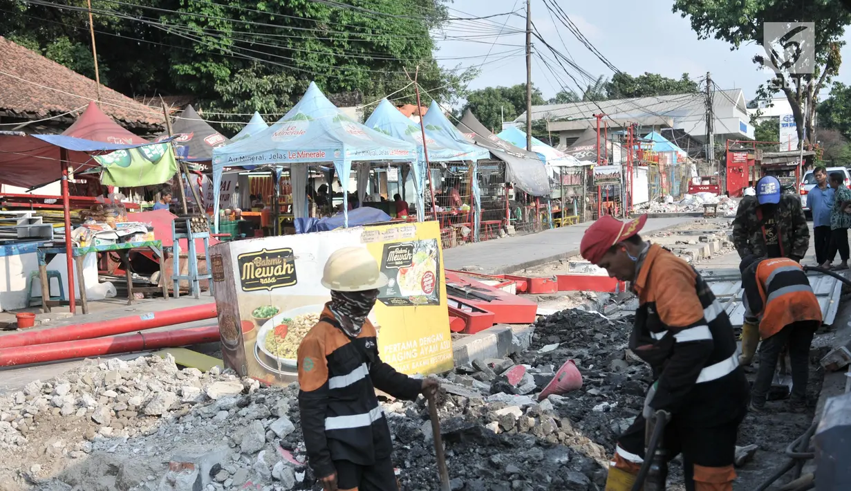 Pekerja menyelesaikan proyek trotoar Jalan Kramat Raya, Jakarta, Senin (16/9/2019). Para pedagang Nasi Kapau dan makanan ringan khas Sumatera Barat di kawasan Kramat Raya tetap bertahan untuk berjualan meski kios mereka tergusur akibat proyek pelebaran trotoar. (merdeka.com/Iqbal S. Nugroho)