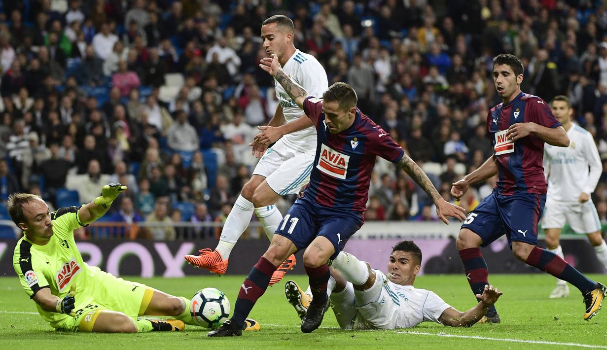 Kiper Eibar, Marko Dmitrovic (kiri) berusaha mengamankan bola dari kejaran para pemain Real Madrid pada lanjutan La Liga Santander di Santiago Bernabeu stadium, Madrid, (22/10/2017). Madrid menang 3-0. (AFP/Pierre-Philippe Marcou)