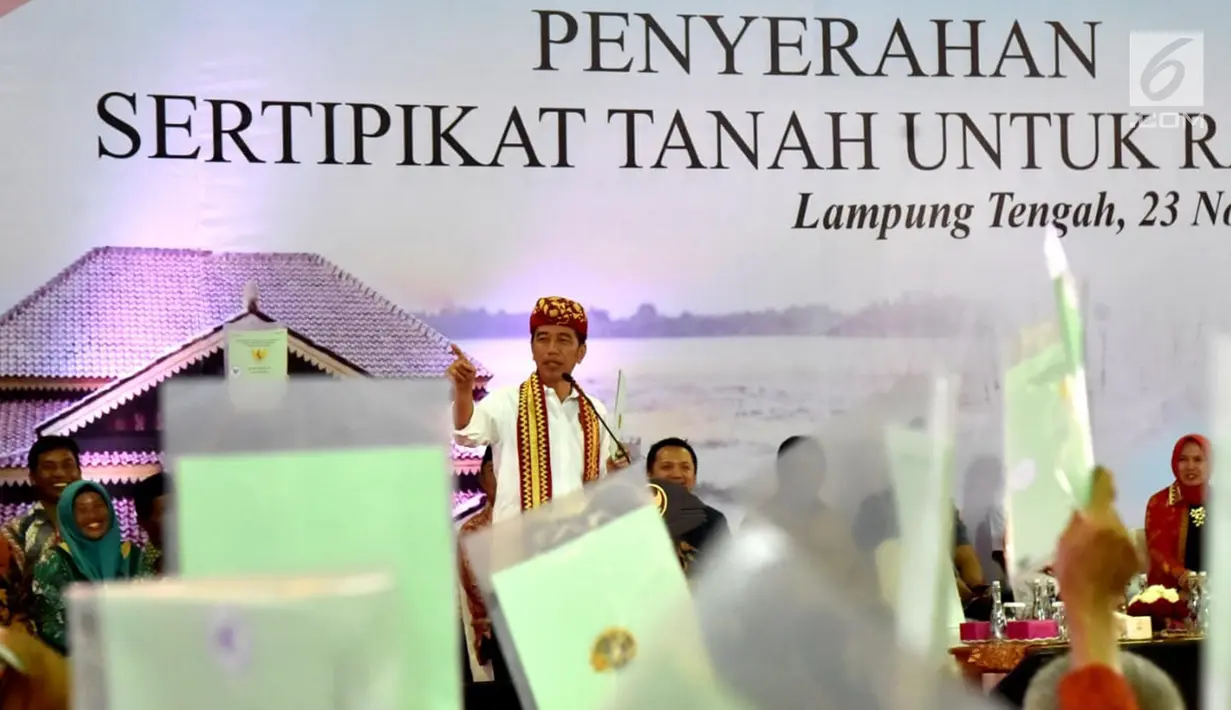 Presiden Joko Widodo saat menyerahkan langsung 1.300 sertifikat hak atas tanah untuk masyarakat di Kabupaten Lampung Tengah, Jumat (23/11). Penyerahan sertifikat ini dilakukan di Gedung Lapangan Tenis Pemda Lampung Tengah. (Liputan6.com/HO/Biropers)