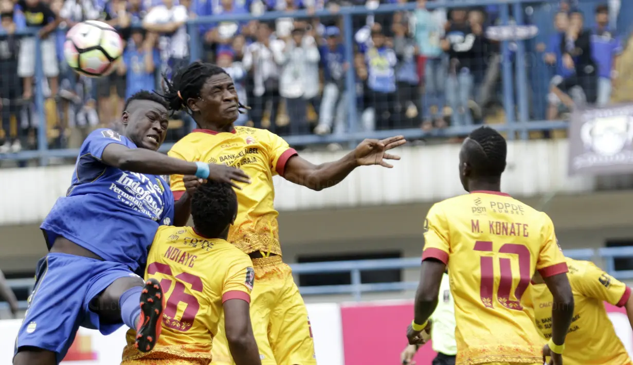 Striker Persib, Ezechiel Ndouassel, duel udara dengan bek Sriwijaya FC, Bio Paulin, pada laga Piala Presiden di Stadion GBLA, Bandung, Selasa (16/1/2018). Persib menang 1-0 atas Sriwijaya FC. (Bola.com/M Iqbal Ichsan)