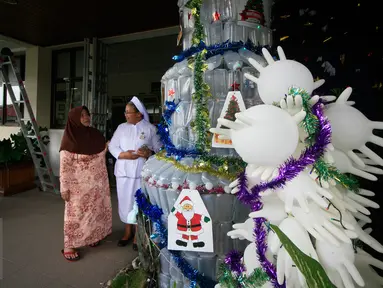 Seorang suster saat menjelaskan kepada pengunjung tentang pohon Natal dari limbah medis di RS Panti Nugroho, Sleman, Rabu (23/12). Ratusan infus, sarung tangan dan masker bekas pakai yang telah disterilkan dirangkai menjadi pohon Natal. (Boy Harjanto)