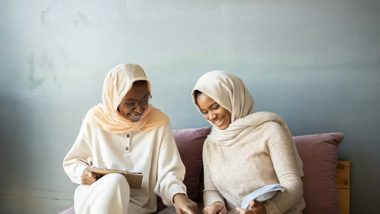 Dua wanita muslimah membaca buku