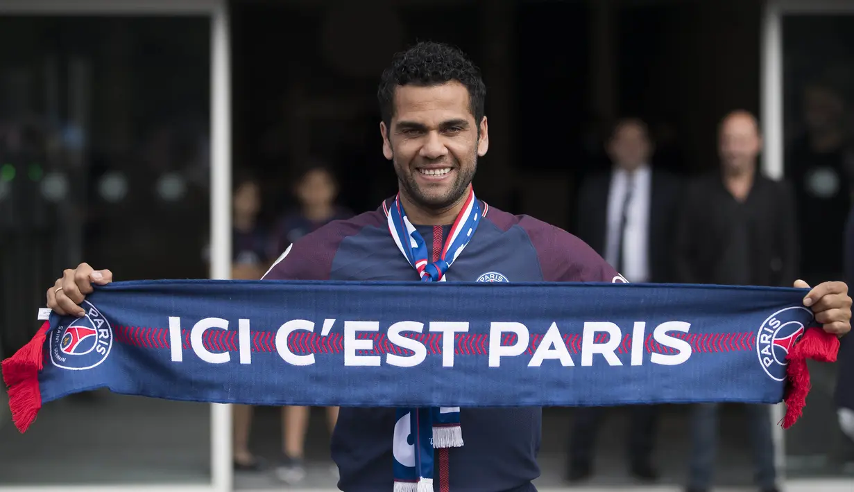 Mantan bek Juventus, Dani Alves, mengangkat syal saat diperkenalkan sebagai pemain baru PSG di Stadion Parc des Princes, Paris, Rabu (12/7/2017). (EPA/Ian Langsdon)