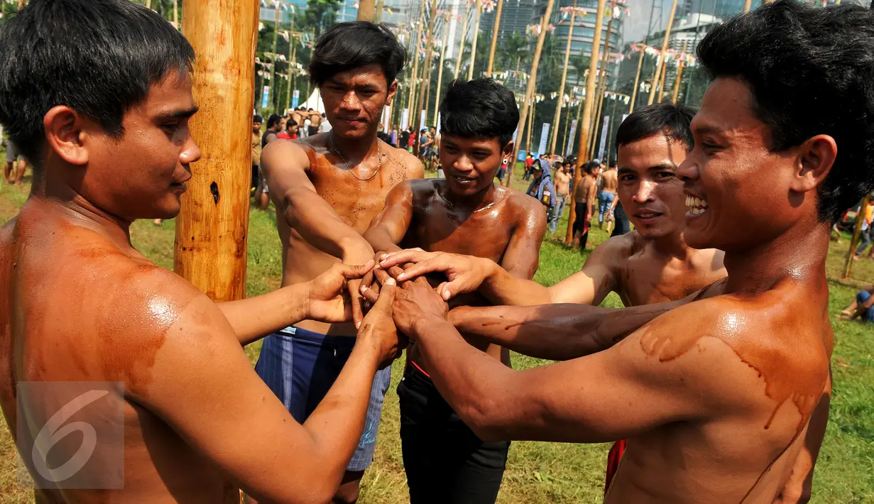 Peserta saling memberi semangat saat mengikuti lomba panjat pinang massal dalam rangka merayakan HUT Kemerdekaan RI ke-71 di lapangan ex Golf Driving Range Senayan, Jakarta, Rabu (17/8). (Liputan6.com/Gempur M Surya)