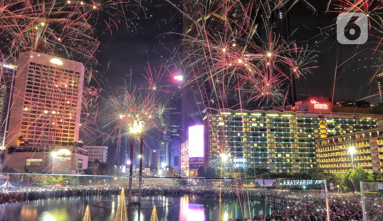Warga menyaksikan pesta kembang api menyambut tahun baru 2023 di kawasan Bundaran HI, Jakarta, Senin (1/1/2023). Pemprov DKI Jakarta menggelar "car free night" hingga 1 Januari 2023 pukul 02.00 WIB dalam rangka menyambut tahun baru 2023. (Liputan6.com/Angga Yuniar)