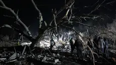 Petugas polisi Ukraina dan petugas penyelamat membersihkan puing-puing rumah pribadi yang hancur setelah serangan roket Rusia di Kramatorsk, wilayah Donetsk, pada 17 Februari 2024. (Anatolii STEPANOV/AFP)