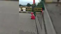Dua emak-emak lakukan aksi tolak bala di Jembatan Kembar (Facebook/Istimewa)