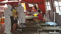 Petugas medis membawa pasien COVID-19 menuju tenda darurat di RSUD Bekasi, Rabu (23/6/2021). Tenda darurat didirikan sebagai upaya menambah ruang IGD yang dapat menampung 30 pasien menyusul ruangan di rumah sakit sudah penuh akibat lonjakan kasus Covid-19. (Liputan6.com/Herman Zakharia)