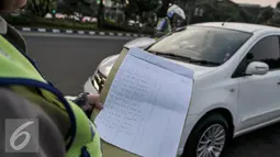 Petugas saat menegur pengendara di jalan Medan Merdeka Barat, Jakarta, Jumat (5/8). Berdasarkan data Polda Metro Jaya, terhitung 27 Juli hingga 3 Agustus 2016 jumlah pelanggaran ganjil-genap mencapai 5.947 pelanggar. (Liputan6.com/Yoppy Renato)