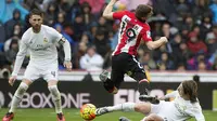 Pemain Athletic Bilbao, Iker Muniain (tengah) menerima tackle dari pemain Real Madrid, Luka Modric pada lanjtan La Liga Spanyol pekan ke-24 di Stadion Santiago Bernabeu,  Madrid, Sabtu (13/2/2016).  (AFP / Curto De La Torre)