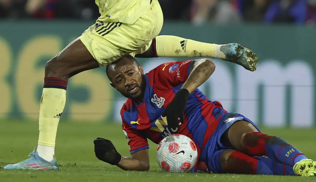 Penyerang Crystal Palace, Jordan Ayew berebut bola dengan gelandang Arsenal, Thomas Partey pada pertandingan lanjutan Liga Inggris di stadion Selhurst Park di London, Inggris, Selasa (5/4/2022). Crystal Palace menang telak atas Arsenal 3-0. (AP Photo/Ian Walton)
