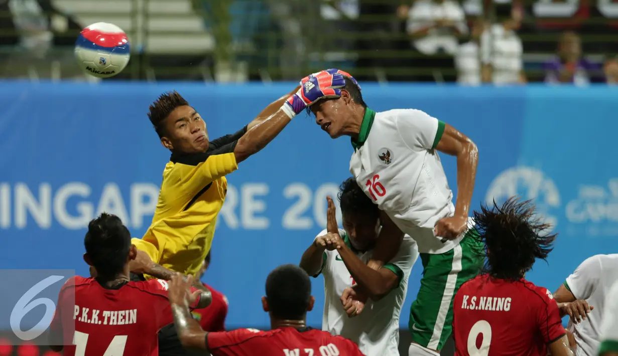 Penjaga gawang Myanmar U-23, Kyaw Zin Phyo (kiri) berusaha menahan sundulan Hansamu Yama Pranata (Indonesia) di penyisihan grup A Sea Games 2015 di Stadion Jalan Besar, Singapura, Selasa (2/6/2015). Indonesia kalah 4-2. (Liputan6.com/Helmi Fithriansyah)
