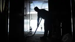Salah satu pekerja membersihkan karpet yang ada di dalam ruang sidang utama di gedung DPR RI, (8/8/2014). (Liputan6.com/Faisal R Syam)
