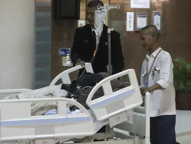 Petugas membawa Julia Perez alias Jupe ke ruang perawatan usai menjalani cuci darah di RSCM, Jakarta (21/4). Pelantun lagu Belah Duren tersebut terlihat terbaring lemah dengan kondisi kepala tertutup kain hitam. (Liputan6.com/Herman Zakharia)