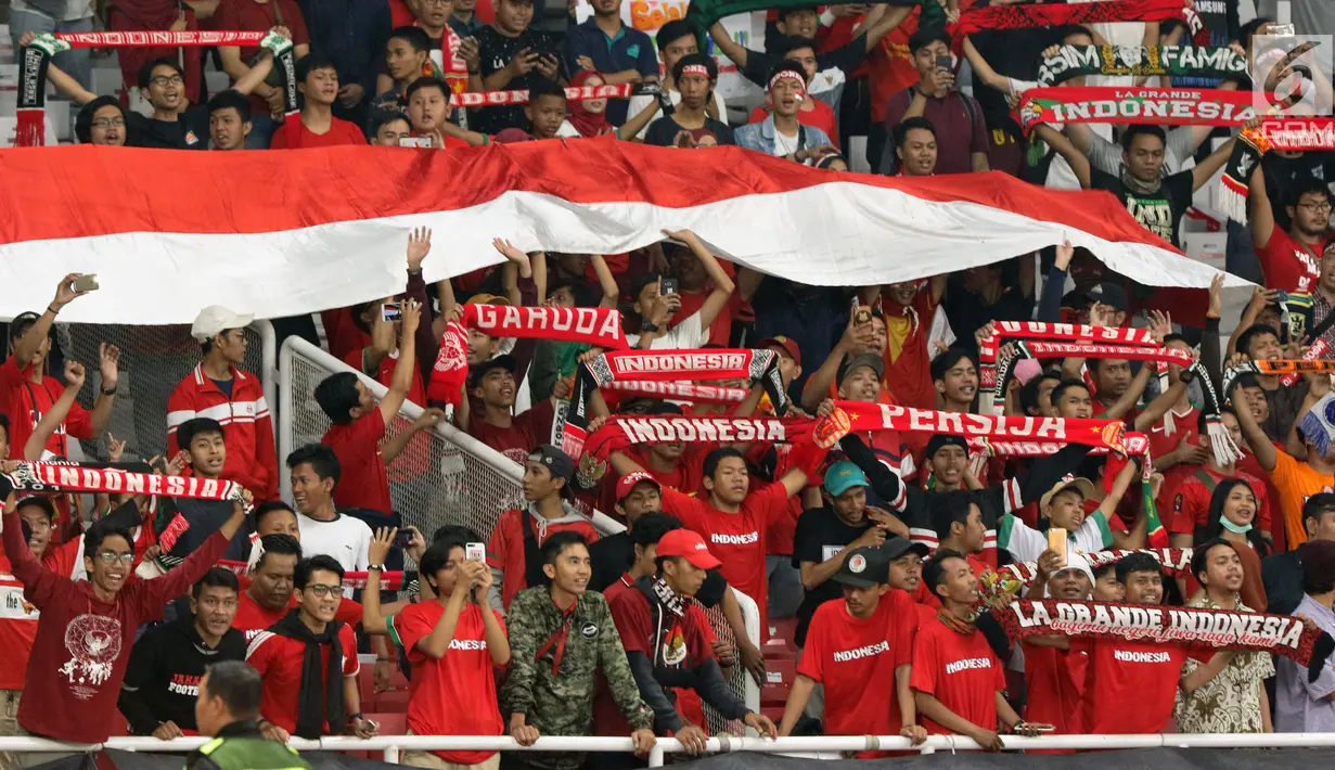 Suporter membentangkan bendera Merah Putih jelang menyaksikan laga Timnas Indonesia U-19 melawan Chinnese Taipei pada penyisihan Grup A Piala AFC U-19 2018 di Stadion GBK, Jakarta, Kamis (18/10). Indonesia unggul 3-1. (Liputan6.com/Helmi Fithriansyah)