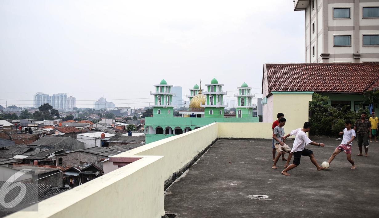 Sejumlah remaja bermain futsal di atas gedung di Pasar Mampang, Jakarta, Rabu (12/7).  Karena kurangnya lahan tempat bermain futsal di jakarta sehingga atas gedung menjadi tempat bermain tanpa menghiraukan keselamatan. (Liputan6.com/Faizal Fanani)