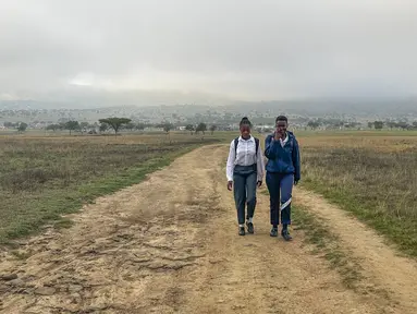 Luyanda Hlali (kiri) dan temannya Mimi Dubazane memulai rutinitas berjalan kaki selama 2 jam dari desa Stratford ke sekolah mereka di Dundee, Afrika Selatan, Kamis, 26 Oktober 2023. (AP Photo/ Mogomotsi Magome)