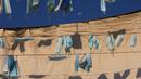 Masker wajah digantung di kapal selama penguncian nasional untuk mengekang penyebaran virus corona, di pelabuhan di kota campuran Arab Yahudi Jaffa, dekat Tel Aviv, Israel, Rabu (7/10/2020). (AP Photo/Oded Balilty)