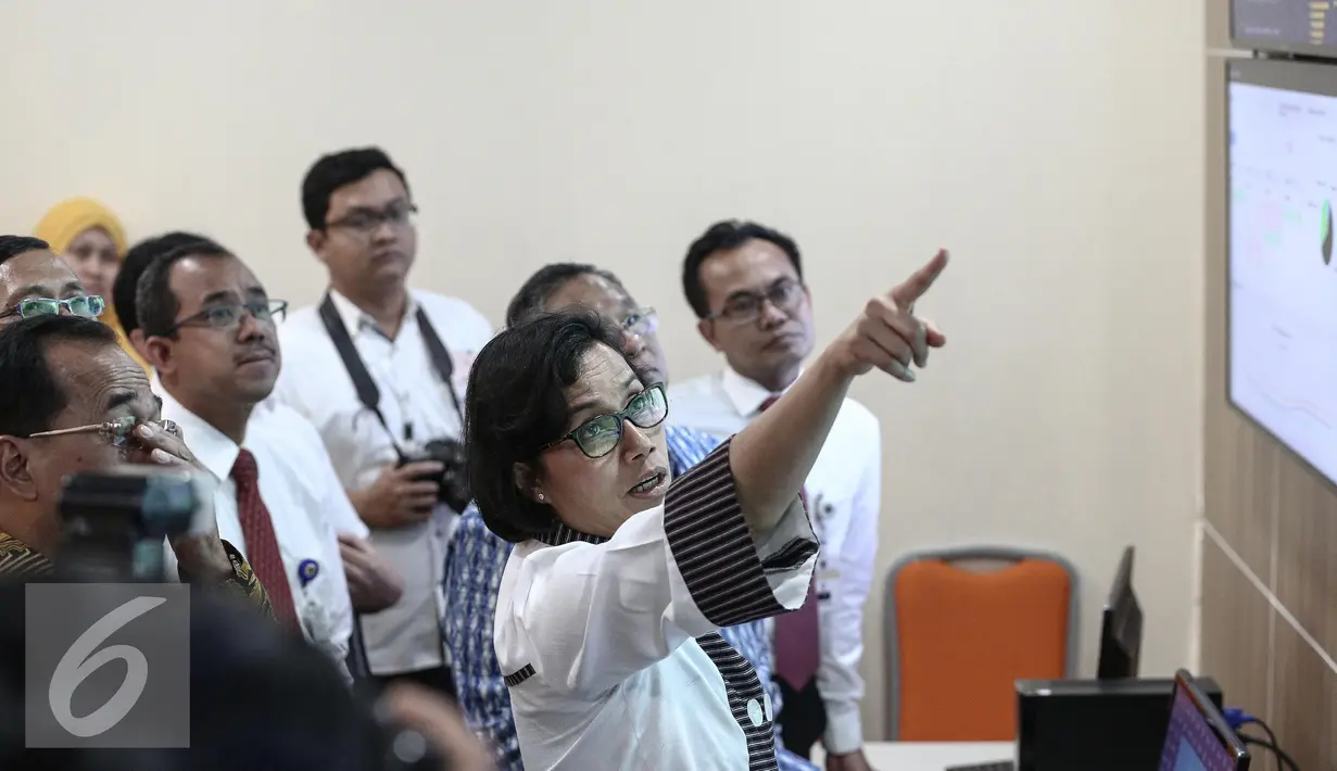 Menteri Keuangan Sri Mulyani memperhatikan layar monitor saat melihat proses layanan dwelling time di kantor pengelola portal Indonesia National Single Window (INSW), Jakarta, Senin (6/2). (Liputan6.com/Faizal Fanani)