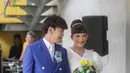 Qibil dengan setelan jas berwarna biru, sementara Qurrotu mengenakan dress putih dengan detail bunga-bunga warna biru. [Foto: IG/bahagia.wedding].