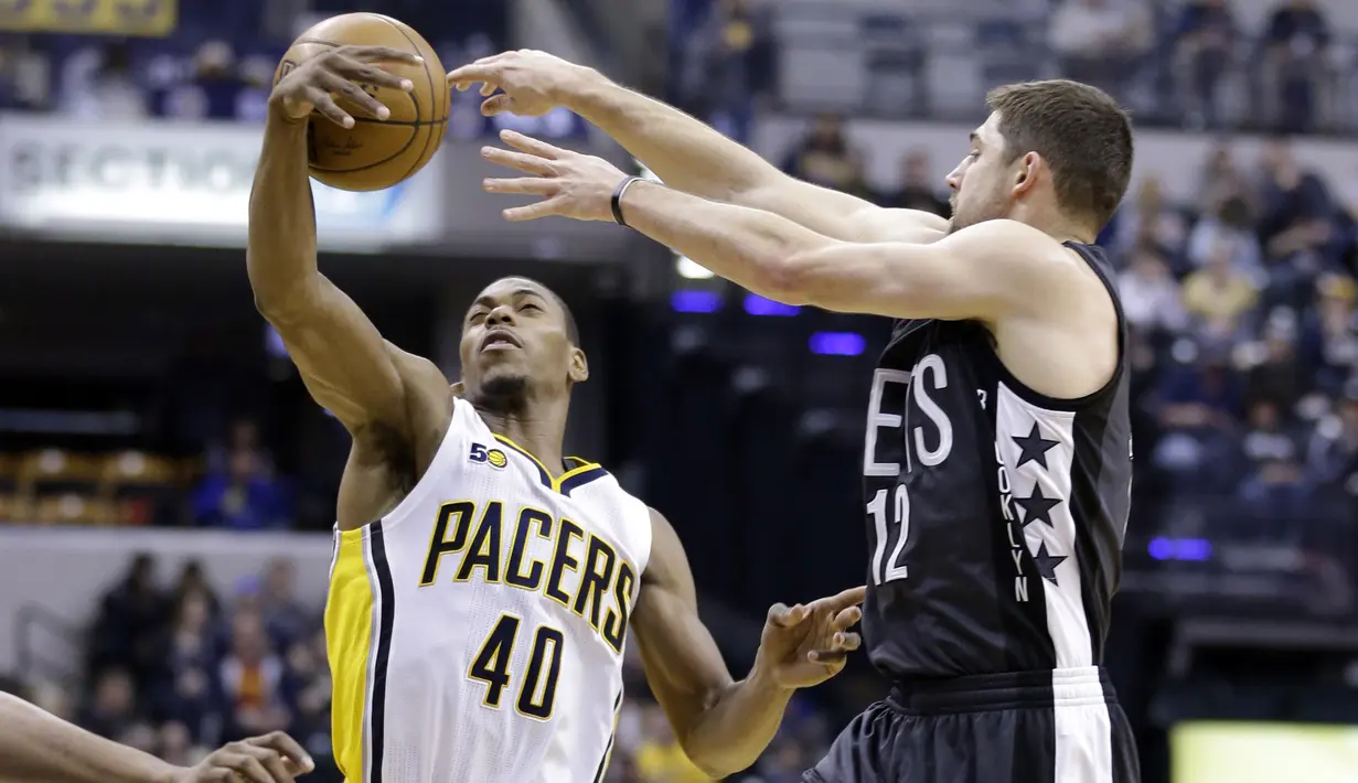 Aksi pemain Indiana Pacers, Glenn Robinson III (kiri) menghadang umpan pemain Brooklyn Nets, Joe Harris (kanan) pada laga lanjutan NBA di  Bankers Life Fieldhouse, Indianapolis, (5/1/2017).  Pacers menang 121-109. (AP/Michael Conroy)