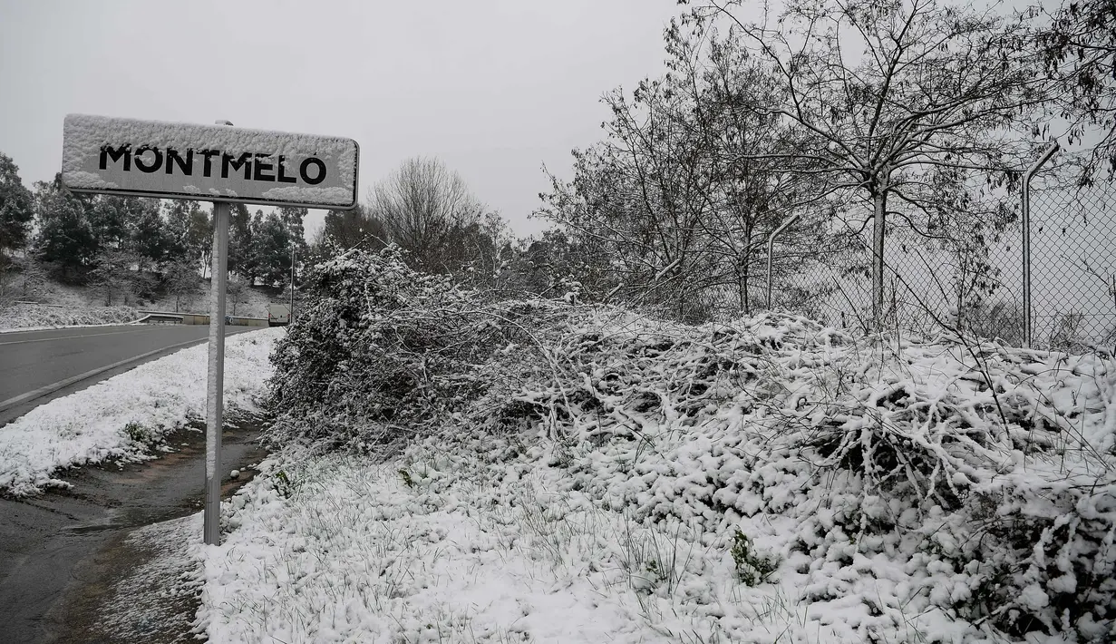 Salju menutupi tanda penunjuk jalan saat hujan salju di Sirkuit de Catalunya di Montmelo di pinggiran kota Barcelona (28/2). Sirkuit ini akan digunakan untuk musim pertama tes Formula 1 Grand Prix. (AFP Photo/Josep Lago)