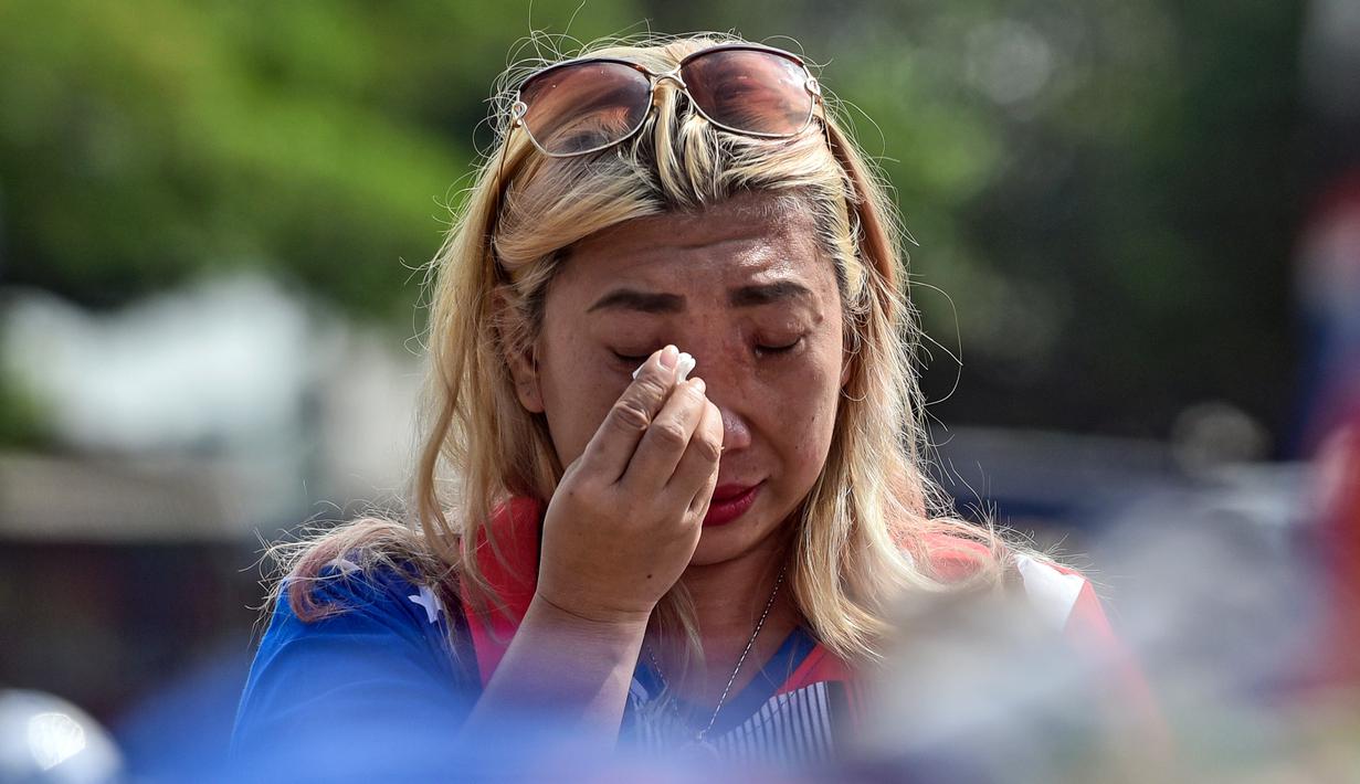 Seorang wanita menangis saat berdoa di luar Stadion Kanjuruhan, Malang, Jawa Timur, Selasa (4/10/2022). Polri menjatuhkan sanksi kepada 10 anggota polisi dan menyelidiki 18 orang lainnya buntut tragedi kerusuhan yang menewaskan 125 orang di Stadion Kanjuruhan. (AP Photo/Dicky Bisinglasi)