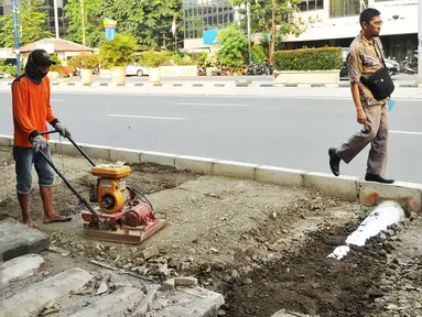 Pekerja menyelesaikan pembangunan trotoar di jalan Suryopranoto, Jakarta, Selasa (2/8). Pemprov DKI telah melakukan perbaikan dan pembangunan trotoar untuk kenyamanan pejalan kaki di 48 lokasi. (Liputan6.com/Gempur M Surya) 