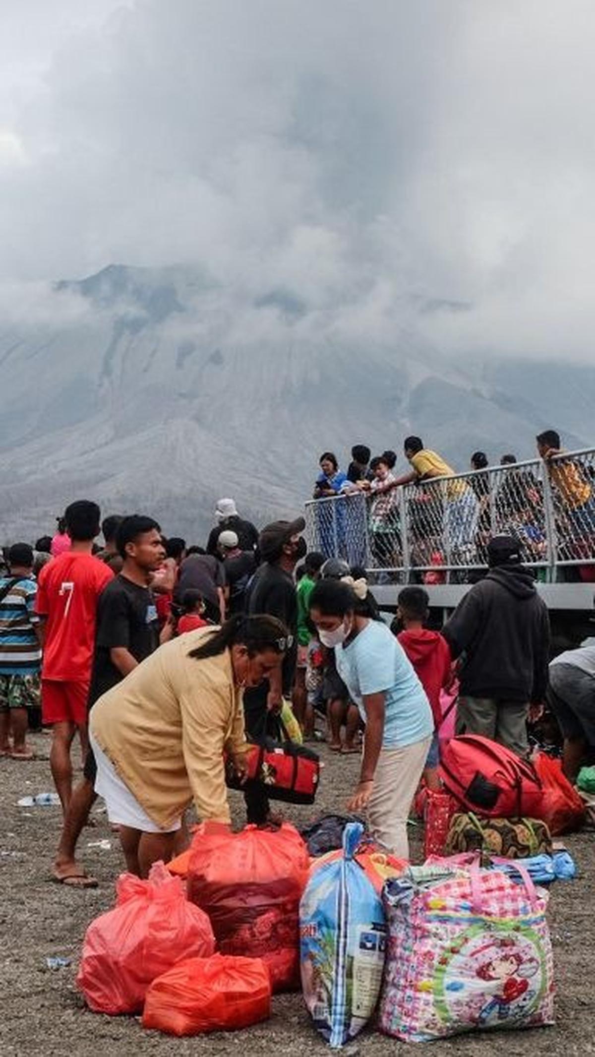 Ribuan orang yang tinggal di pulau-pulau terdekat Gunung Ruang pun secara bertahap menyelamatkan diri.&nbsp;Mereka menaiki sejumlah kapal evakuasi yang dikerahkan TNI AL, Polri, hingga Basarnas.&nbsp;Foto: Ronny Adolof Buol/AFP