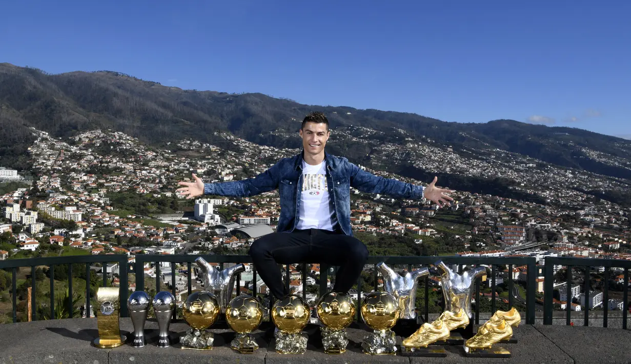 Bintang Real Madrid, Cristiano Ronaldo, menunjukan trofi pribadi di kampung halamannya di Madeira, Portugal, Senin (1/1/2018). Pemain bernomor punggung tujuh itu memamerkan 15 trofi individual yang ia raih sebagai pemain terbaik. (AFP/CR7 Media)