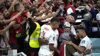 Bek Timnas Maroko, Achraf Hakimi, memeluk ibunya setelah timnya menggilas Belgia 2-0 pada matchday kedua fase Grup E Piala Dunia 2022 di Al Thumama Stadium, Minggu (27/11/2022). (AP/Christope Ena)