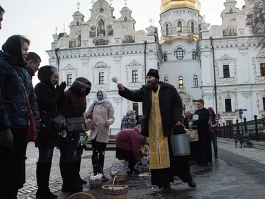 Imam Ortodoks Ukraina memberkati jemaatnya saat perayaan Paskah di gereja Kyiv-Pechersk Lavra di Kiev, Ukraina (8/4). Gereja Ortodoks Timur biasanya merayakan Paskah beberapa minggu setelah perayaan Paskah di gereja Barat. (AP Photo / Evgeniy Maloletka)