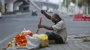 Seorang penjual bunga membuat karangan bunga di pinggir jalan di Jammu, India pada Selasa (4/5/2021).  India pada Selasa (4/5) mengonfirmasi lebih dari 20 juta infeksi virus corona, setelah mencatat 357.229 kasus baru selama 24 jam terakhir. (AP Photo/Channi Anand)