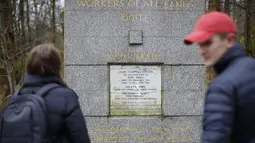 Pengunjung melihat makam filsuf ternama Jerman dan tokoh sosialisme, Karl Marx, di Pemakaman Highgate, London, Selasa (5/2). Permukaan marmer yang diambil dari makam asli Marx saat disemayamkan pada 1883 itu mengalami kerusakan parah. (Tolga AKMEN/AFP)