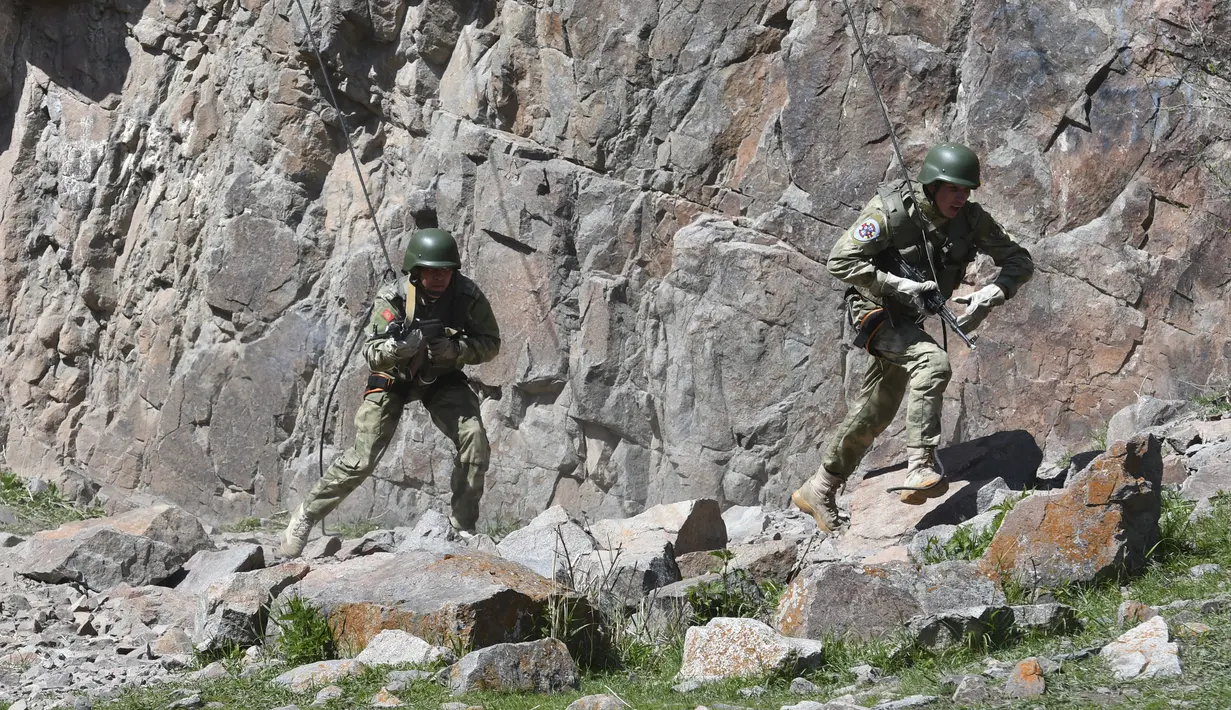 Pasukan menuruni tebing saat ikut serta dalam latihan gabungan Kyrgyzstan dan India di Ngarai Tatyr, selatan Bishkek, dekat Desa Arashan, Kyrgyzstan, Senin (26/4/2021). Pasukan tersebut berlatih untuk mengoordinasikan aksi mereka melawan militan. (AP Photo/Vladimir Voronin)